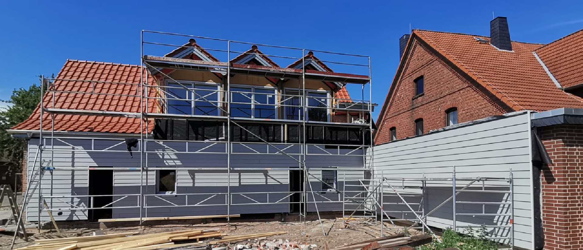 Sanierung eines Wohnhauses: Fassade und Dach werden unter Einsatz von Gerüstarbeiten modernisiert und energetisch aufgewertet.
