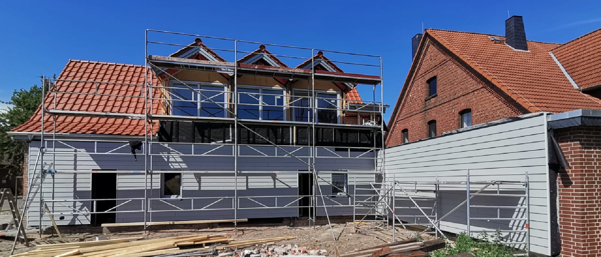 Sanierung eines Wohnhauses: Fassade und Dach werden unter Einsatz von Gerüstarbeiten modernisiert und energetisch aufgewertet.